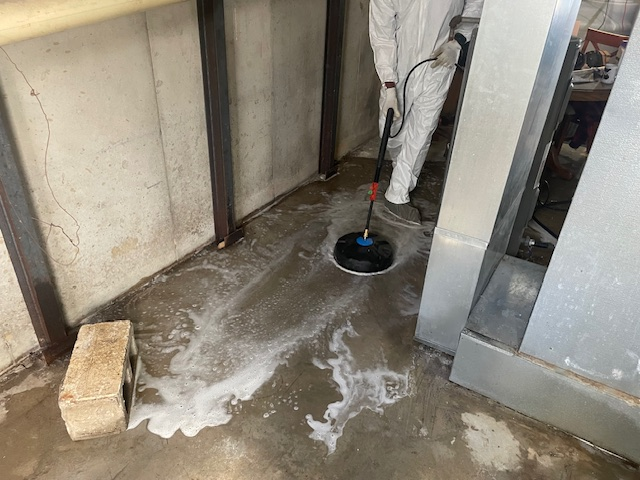 Restor KC technician scrubbing and disinfecting a contaminated basement floor