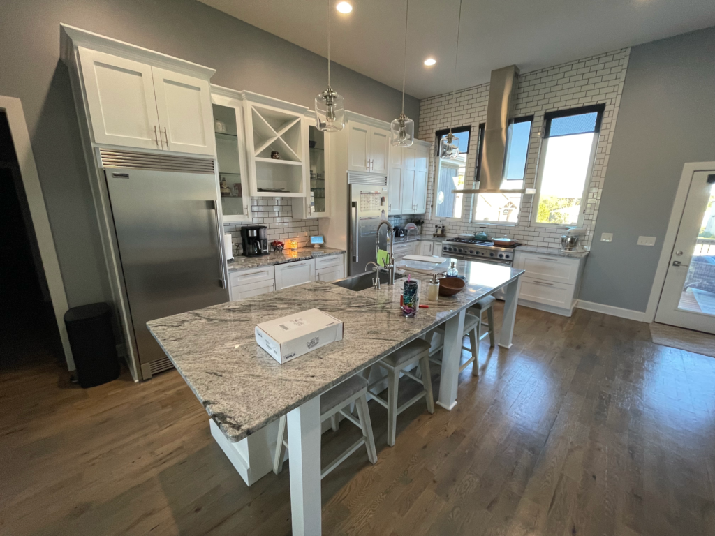 White shaker kitchen with granite island and stainless appliances, remodeled by Restor KC in Kansas City