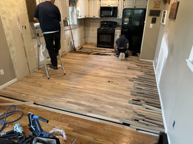 Old wallpaper being stripped in a Kansas City kitchen during Restor KC reconstruction