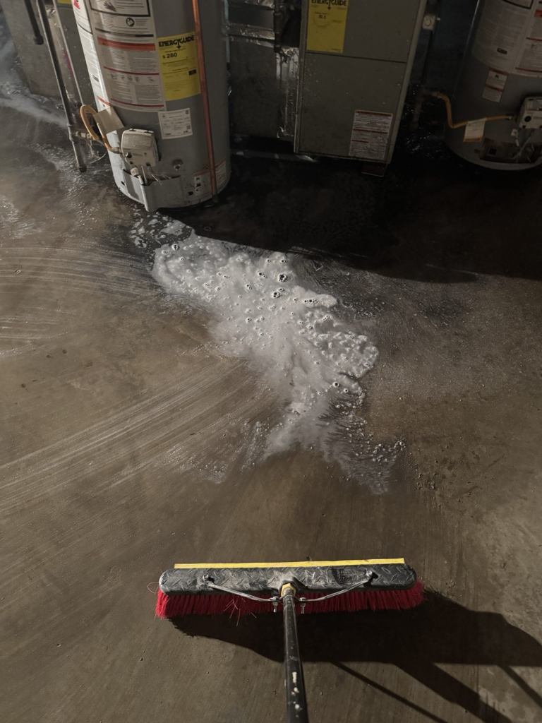Restor KC technician disinfecting a basement floor after a sewage backup